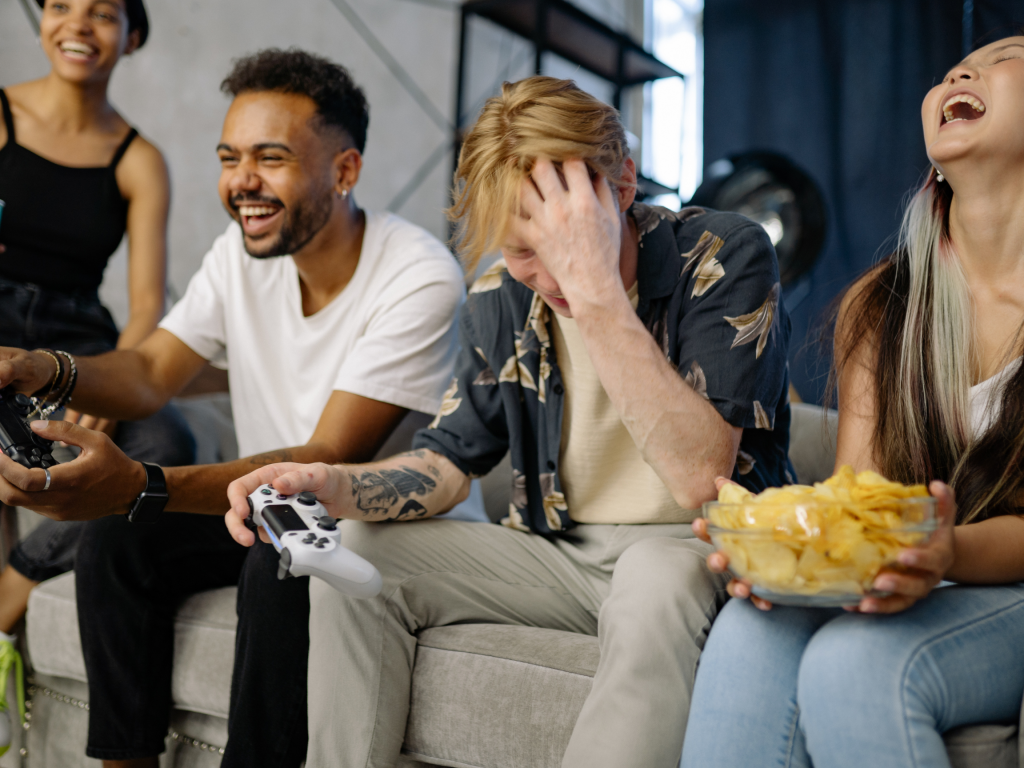 Students laughing while playing video games. 